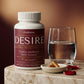 Daily ritual setup with YouRenew DESIRE bottle, water glass, and two amber capsules in ceramic dish on marble surface